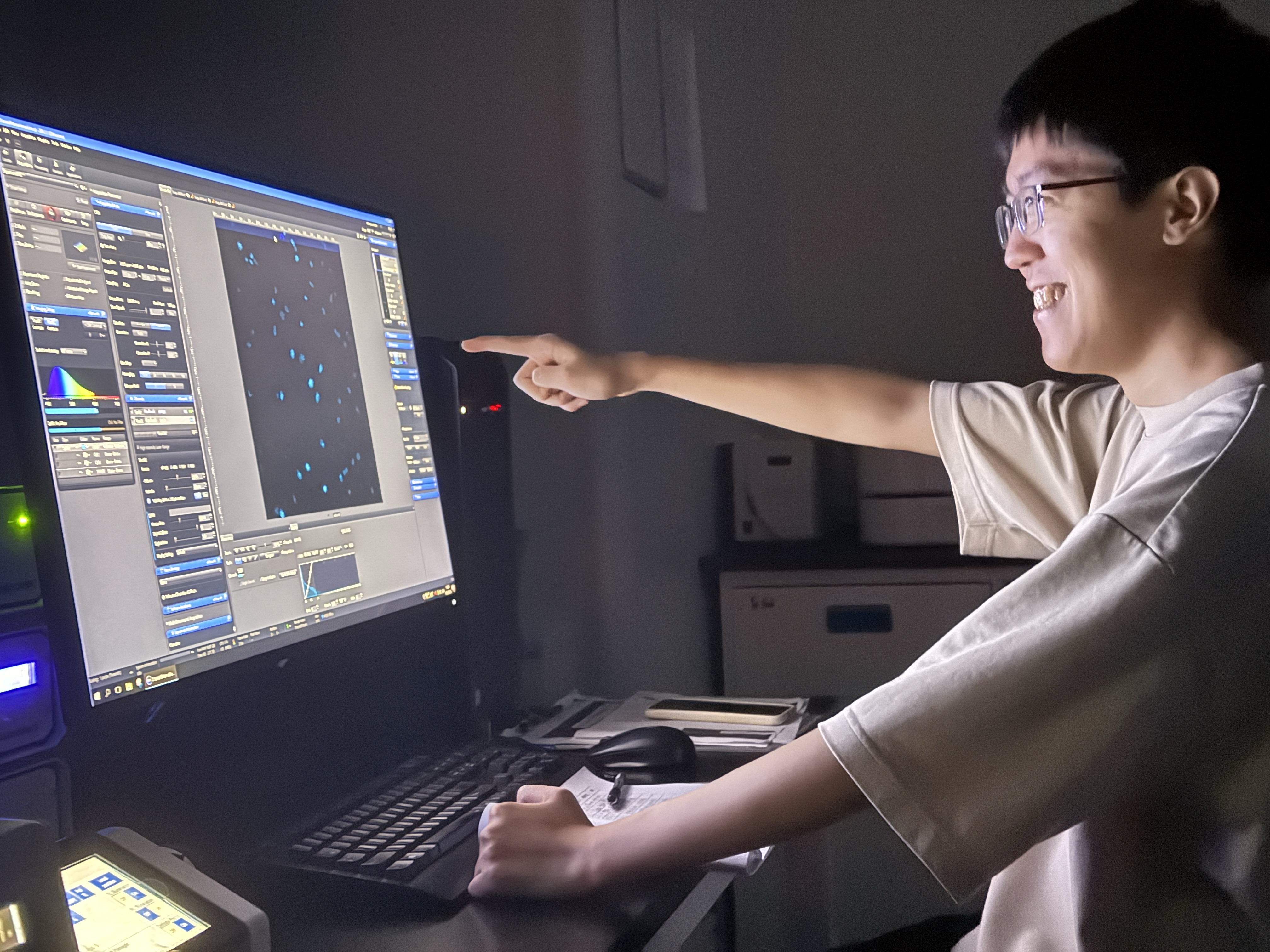 Pengxiang Tang examining microscopy images in the laboratory